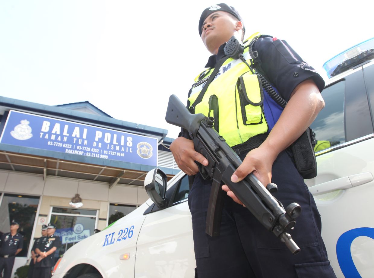 Police patrol personnel standing guard at Taman Tun Dr Ismail police station.