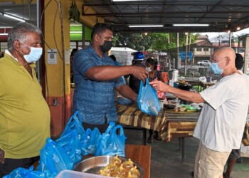 NIBONG TEBAL, 19 Jan -- Sedar akan situasi kehidupan orang ramai kian terhimpit dek pandemik COVID-19, seorang pengusaha restoran makanan di Jalan Ooi Kar Seng di sini mengambil inisiatif dengan menawarkan makanan percuma kepada mereka yang memerlukan.Pemilik Restoran Big Boss Banana Leaf, M.Moganasundram, 37, memberi makanan percuma berbentuk 100 bungkus nasi berlauk setiap hari sehingga tempoh Perintah Kawalan Pergerakan (PKP).Tambahnya lagi, setiap hari menu makanan berlainan disediakan, antaranya nasi putih, telur masak sambal, ikan goreng, ayam, sayur dan juga kuah.Beliau bersama pekerja restoran menyediakan lauk pauk bermula 3 petang hingga 5 petang dan membungkus makanan tersebut sebelum diedarkan secara terus kepada orang ramai yang datang ke restoran setiap hari dalam tempoh PKP.Ia dapat meringankan sedikit sebanyak beban golongan yang terkesan ketika pandemik COVID-19 yang rata-ratanya mengalami masalah dari segi sumber pendapatan.Kelihatan Moganasundram (kiri) menyampaikan bungkusan makanan percuma kepada golongan yang terjejas akibat pandemik COVID-19 di restorannya di sini.--fotoBERNAMA (2021) HAK CIPTA TERPELIHARA