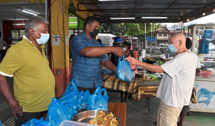 NIBONG TEBAL, 19 Jan -- Sedar akan situasi kehidupan orang ramai kian terhimpit dek pandemik COVID-19, seorang pengusaha restoran makanan di Jalan Ooi Kar Seng di sini mengambil inisiatif dengan menawarkan makanan percuma kepada mereka yang memerlukan.Pemilik Restoran Big Boss Banana Leaf, M.Moganasundram, 37, memberi makanan percuma berbentuk 100 bungkus nasi berlauk setiap hari sehingga tempoh Perintah Kawalan Pergerakan (PKP).Tambahnya lagi, setiap hari menu makanan berlainan disediakan, antaranya nasi putih, telur masak sambal, ikan goreng, ayam, sayur dan juga kuah.Beliau bersama pekerja restoran menyediakan lauk pauk bermula 3 petang hingga 5 petang dan membungkus makanan tersebut sebelum diedarkan secara terus kepada orang ramai yang datang ke restoran setiap hari dalam tempoh PKP.Ia dapat meringankan sedikit sebanyak beban golongan yang terkesan ketika pandemik COVID-19 yang rata-ratanya mengalami masalah dari segi sumber pendapatan.Kelihatan Moganasundram (kiri) menyampaikan bungkusan makanan percuma kepada golongan yang terjejas akibat pandemik COVID-19 di restorannya di sini.--fotoBERNAMA (2021) HAK CIPTA TERPELIHARA